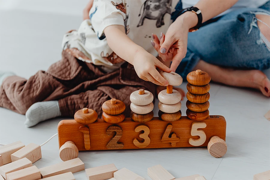 Enfant jouant avec des puzzles et jeux de construction en bois
