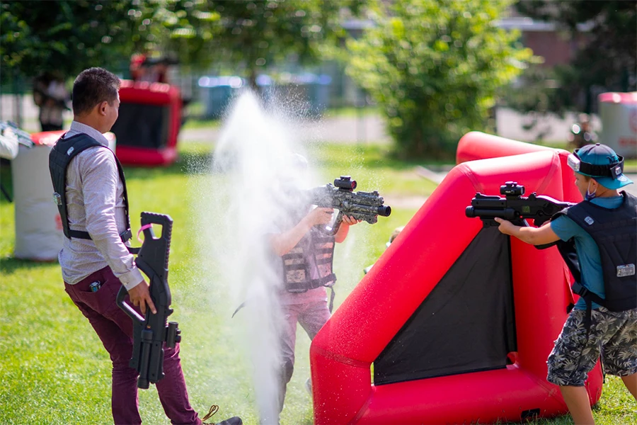 Joueurs équipés de gilets laser game en action dans un jardin