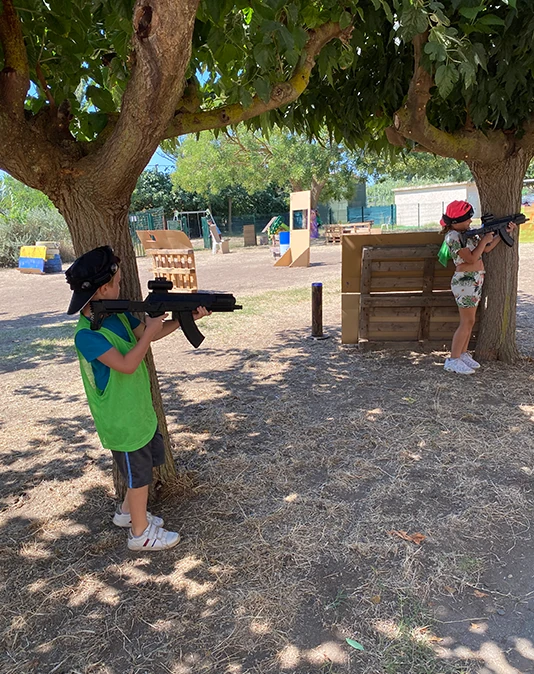 Petit garçon équipé d'un gilet laser game dans un jardin