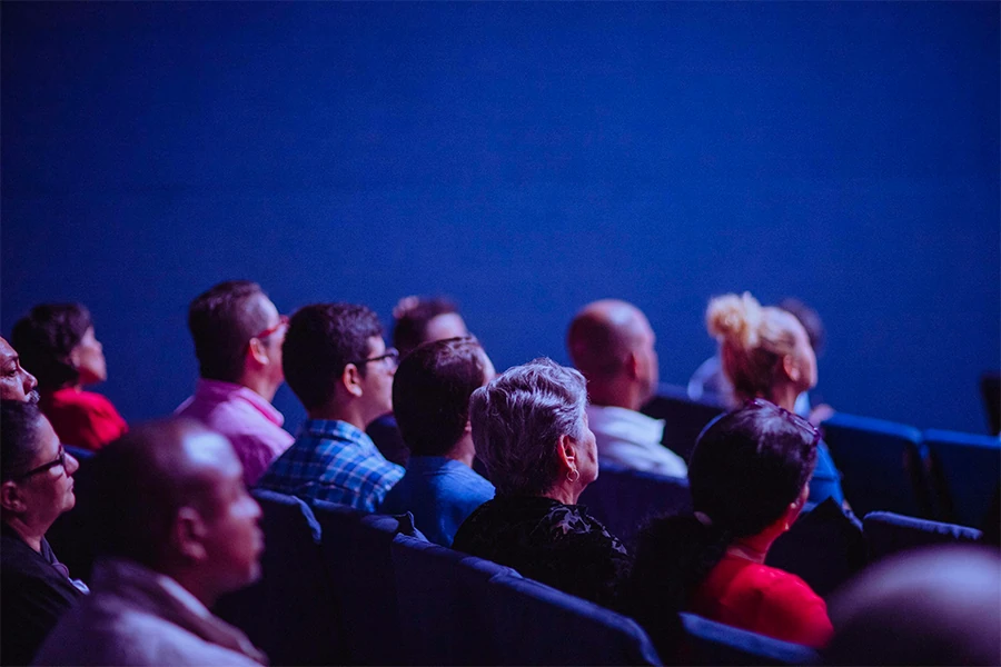 Participants réunis dans une salle de conférence éclairée en bleu lors d'un séminaire d'entreprise