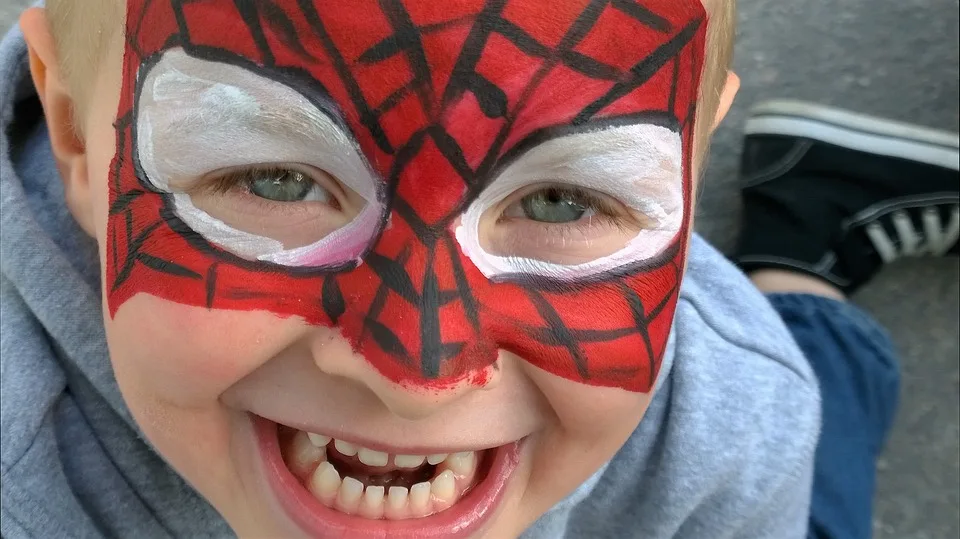 Petit garçon souriant maquillé en Spider-Man lors d'une fête