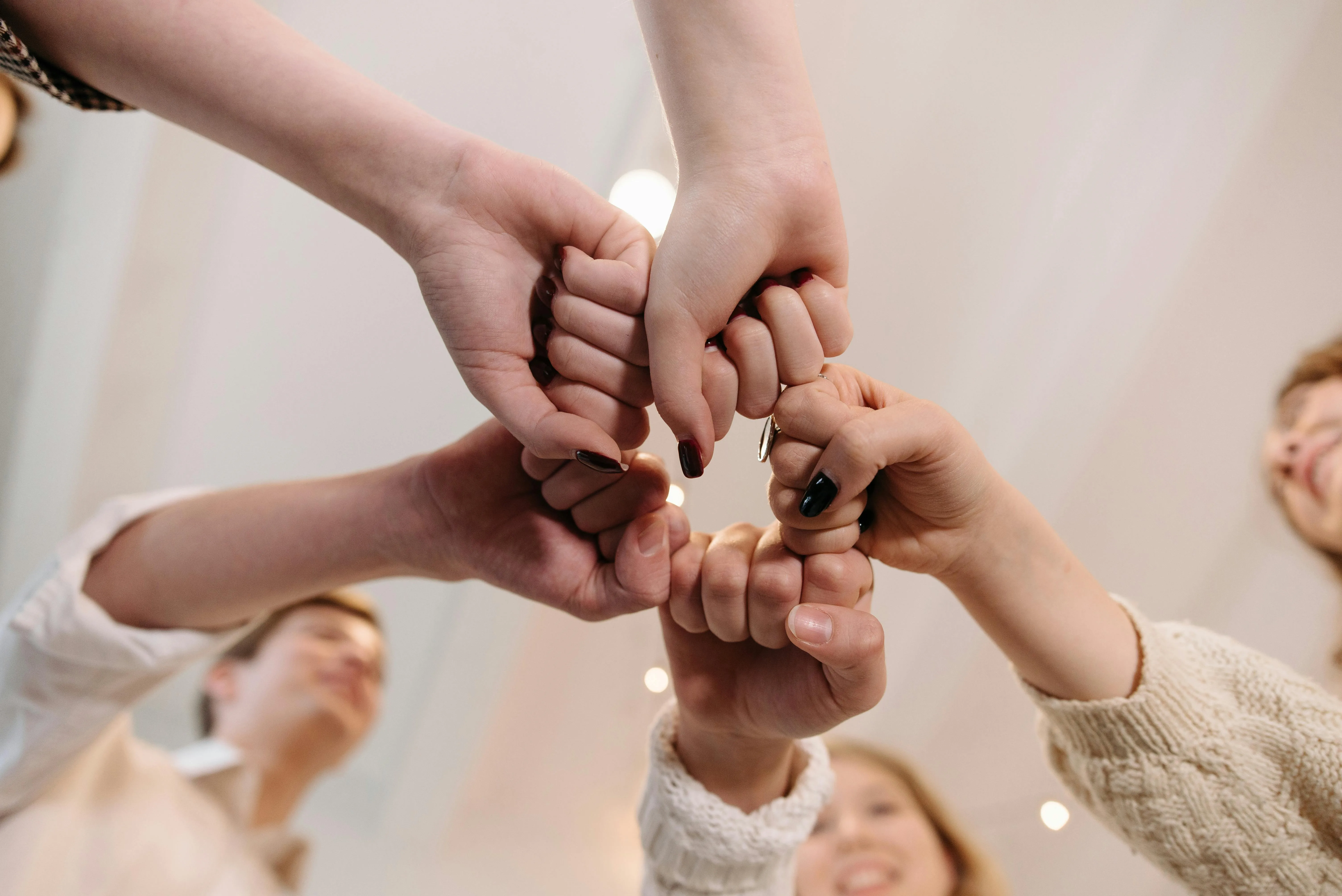 Mains de collègues réunies en cercle, symbole de cohésion d'équipe